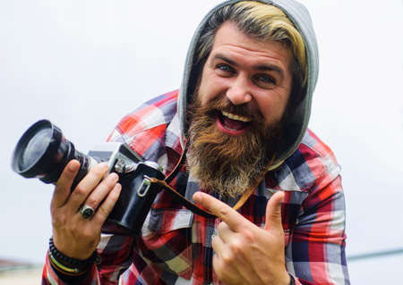 Professional photographer taking photographs on digital camera. Bearded man traveler make photos on...