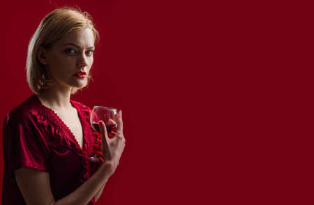 Beautiful woman with glass of red wine. Alcohol. Beauty girl with wineglass. Advertising for restaurant. Copy space.の写真素材