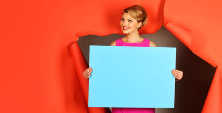 Smiling girl with blank board. Empty banner with Copy space. Advertising billboard. Shopping. Sales.の写真素材