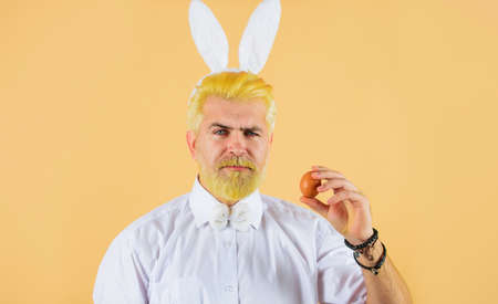 Man in rabbit ears with Easter egg. Spring holidays. Hunting eggs. Bunny guy. Preparing for Easter.の写真素材
