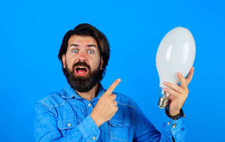 Creative new idea. Surprised man with light bulb. Brainstorming, inspiration. Energy and electricity.の写真素材