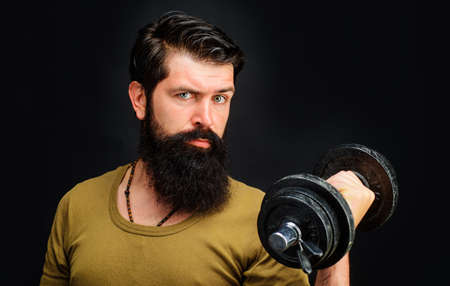 Strong muscular man with dumbbells. Athletic guy lifting dumbell. Sportsman making weightlifting.の写真素材