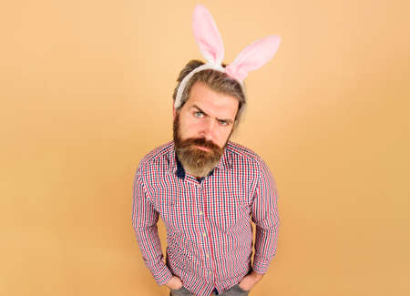 Easter day celebration. Serious bearded man in bunny ears. Rabbit guy. Easter party.の写真素材