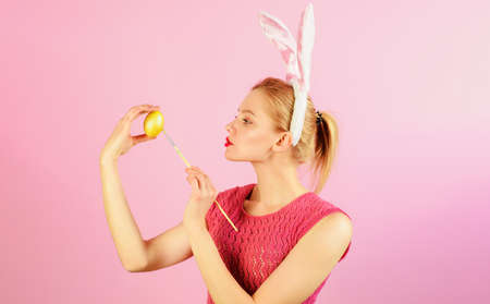 Easter day celebration. Bunny girl with paint brush painting eggs for holiday. Color egg assortment.