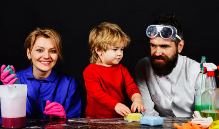 Mother and father teach little son cleans in house. Family clean together. Cleaning day.