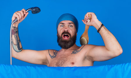 Handsome bearded man take shower. Guy washing body with soap foam and body brush. bath timeの写真素材
