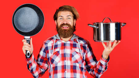 Bearded man with frypan and pot. Frying pan and saucepan. Cooking utensils for food preparation