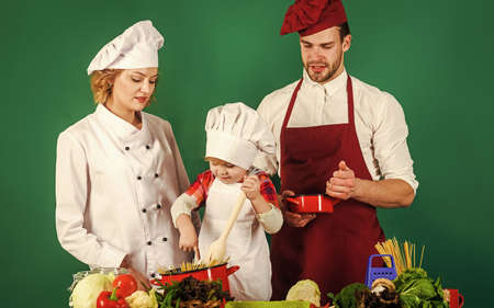 Cook at home. Mother, father and son prepare tasty food at kitchen. family cooking togetherの写真素材