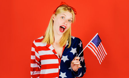 4th July. Smiling girl with flag of United States. independence day celebration. National colors USAの写真素材
