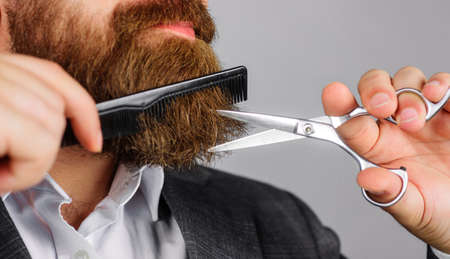 Barbershop. Bearded man with scissor and comb. barber tools. Professional beard care. Salon for menの写真素材