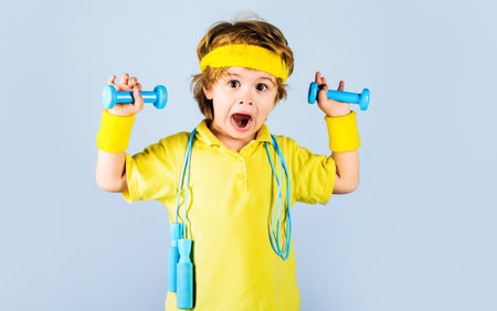 fitness child. Sporty boy with jumping rope and dumbbells. Gym workout. sport. Childhood activityの写真素材
