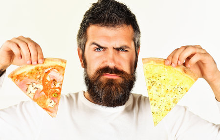 Serious man with pizza slices in hands. Bearded guy with two pieces of pizza. Snack. food deliveryの写真素材