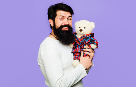 Smiling man with plush toy. Present for birthday. bearded guy with teddy bear. Anniversary, holidayの写真素材