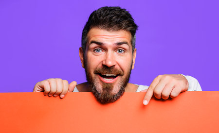 Smiling bearded man with empty advertising banner. Blank sign board with space for text or productの写真素材