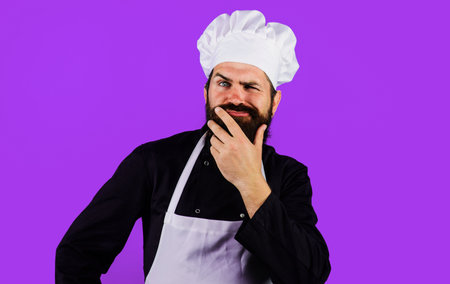 Man chef, cook or baker in uniform thinks what to cook. Cooking, profession and inspiration concept.の写真素材