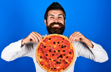 Happy bearded man with tasty pepperoni pizza. fastfood. Pizzeria advertising. food deliveryの写真素材