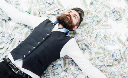 businessman lying in many banknotes. saving money. business success. Rich millionaire, billionaireの写真素材
