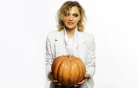 Smiling woman with pumpkin. Jack-o-lantern. Halloween celebration. October 31st. Trick or treatの写真素材