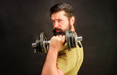 Handsome guy athlete with dumbbell. Strong man training with dumbbells. fitness. Muscular sportsmanの写真素材