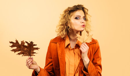 Fashionable woman in trendy clothes with autumn leaves. Autumn mood. season sale. Discountの写真素材