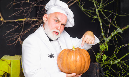 Chef in uniform with pumpkin. happy halloween. Diet food. Healthy organic harvest vegetablesの写真素材