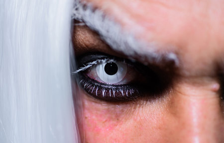 Halloween makeup. Devil, Vampire or Monster Eye Lens. Closeup of man eyes. Horror and scary conceptの写真素材