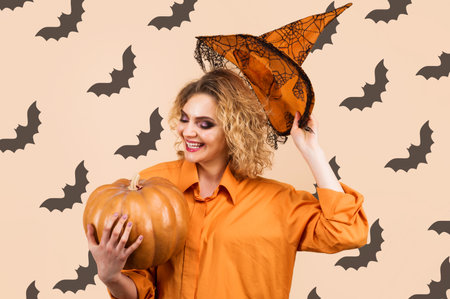 Smiling Witch with Pumpkin. Halloween background. Happy woman in magic hat. Trick or treatの写真素材