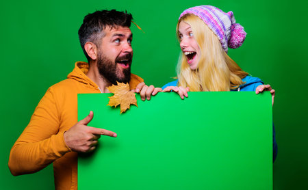 Happy couple with advertising board. autumn sales. Fashion trends for fall. black fridayの写真素材