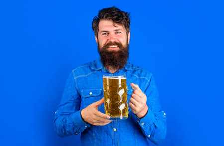 German tradition. Bearded man with cup of beer. alcohol. Stylish guy in jeans shirtの写真素材