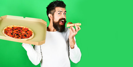 Hungry man eating tasty pizza. food delivery home. Man with beard enjoying delicious pizzaの写真素材