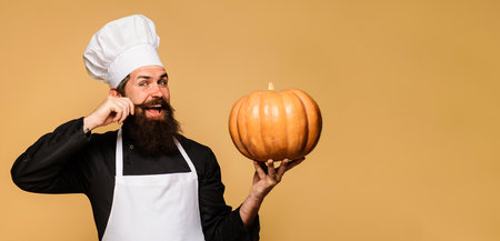 Bearded cook in chef hat with pumpkin. Useful vegetable. Seasonal vitamin. thanksgiving day cookingの写真素材