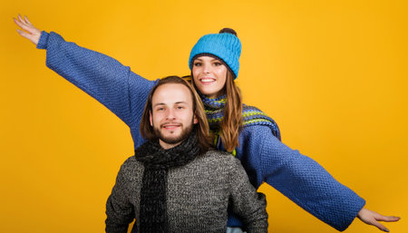 Happy couple in warm clothes. Fashionable man and woman in sweater, scarf and hatの写真素材