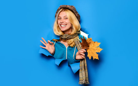 Happy girl in cap and scarf showing ok sign. Autumn collection. Beauty and fashionの写真素材