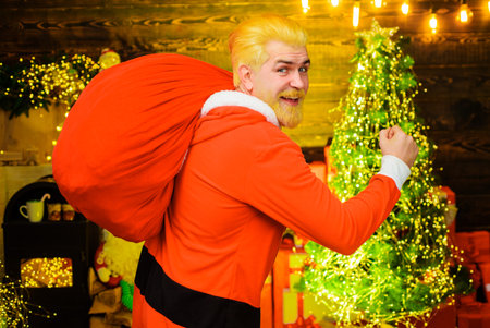 Merry Christmas and happy New year. Santa Claus carrying large sack full of giftsの写真素材