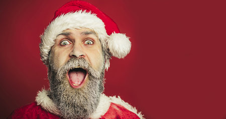 Merry Christmas and Happy New Year. Cheerful Santa Claus man in traditional wear. Closeup portraitの写真素材