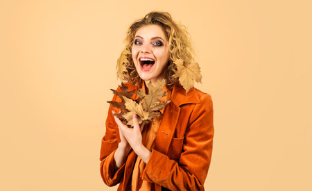 Autumn model. Happy girl with yellow leaves. Season sale. Discount. Fashion trend for fallの写真素材