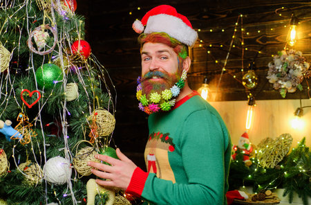 Bearded man in Santa hat near christmas tree. Happy new year. Christmas beard decorationsの写真素材