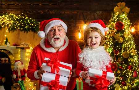 Santa Claus and child boy in room decorated for Christmas with present gift box. Winter holidaysの写真素材