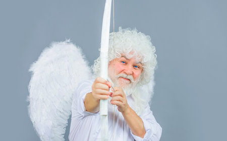 Valentines Day. Valentine cupid shooting arrow with bow. Bearded angel throws arrows of loveの写真素材