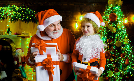 Merry Christmas and happy new year. Santa Claus and child boy with present gift box. Winter holidayの写真素材
