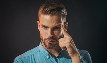 Thinking man. Young handsome man in denim shirt thinking about something. Closeup portrait of concerned guy in casual wear making decision. Thoughtful man worried about question. Pensive expression.の写真素材