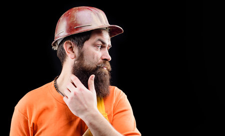 Builder man. Serious builder in protective hard hat. Building industry. Male engineer or industrial worker in hardhat. Hard work. Bearded man in overalls and safety helmet. Copy space for advertisingの写真素材