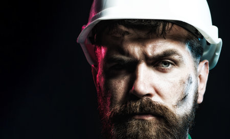 Closeup portrait of pensive architect, foreman or builder in hard hat. Handsome serious engineer or construction worker in safety helmet. Hard work. Builder in hard hat. Building industry. Copy spaceの写真素材
