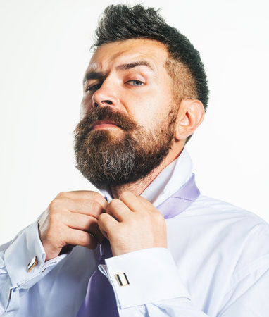 Fashionable bearded man fasten button on shirt. Elegant groom preparing for wedding. Business man preparing for meeting corporate. Stylish businessman getting ready for work. Beginning of working dayの写真素材