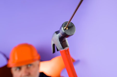 Hammer and nails. Selective focus on hammer and nail. Repair service. Builder hammering nail....