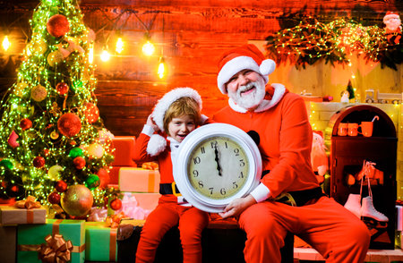 New year midnight. Happy New Year. Cute child boy and smiling bearded man in Santa Claus costumes...