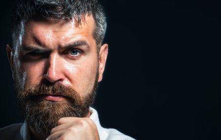 Karate man. Serious karate man in kimono in fighting stance, closeup portrait. Strong karate instructor with clenched fist. Karate fighter preparing for competition at gym. Copy space for advertisingの写真素材