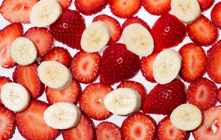 Banana strawberry pile background. Strawberry with bananas. Banana fruit concept background. Fresh ripe bananas and strawberries.の写真素材