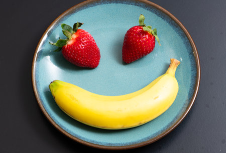 Banana fruit composition. Banana strawberry pile. Fresh ripe bananas and red strawberries. Summer banana background.の写真素材