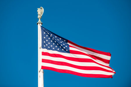 American flag on flagpole. Usa national flag with clear sky. American flag waving on blue sky....